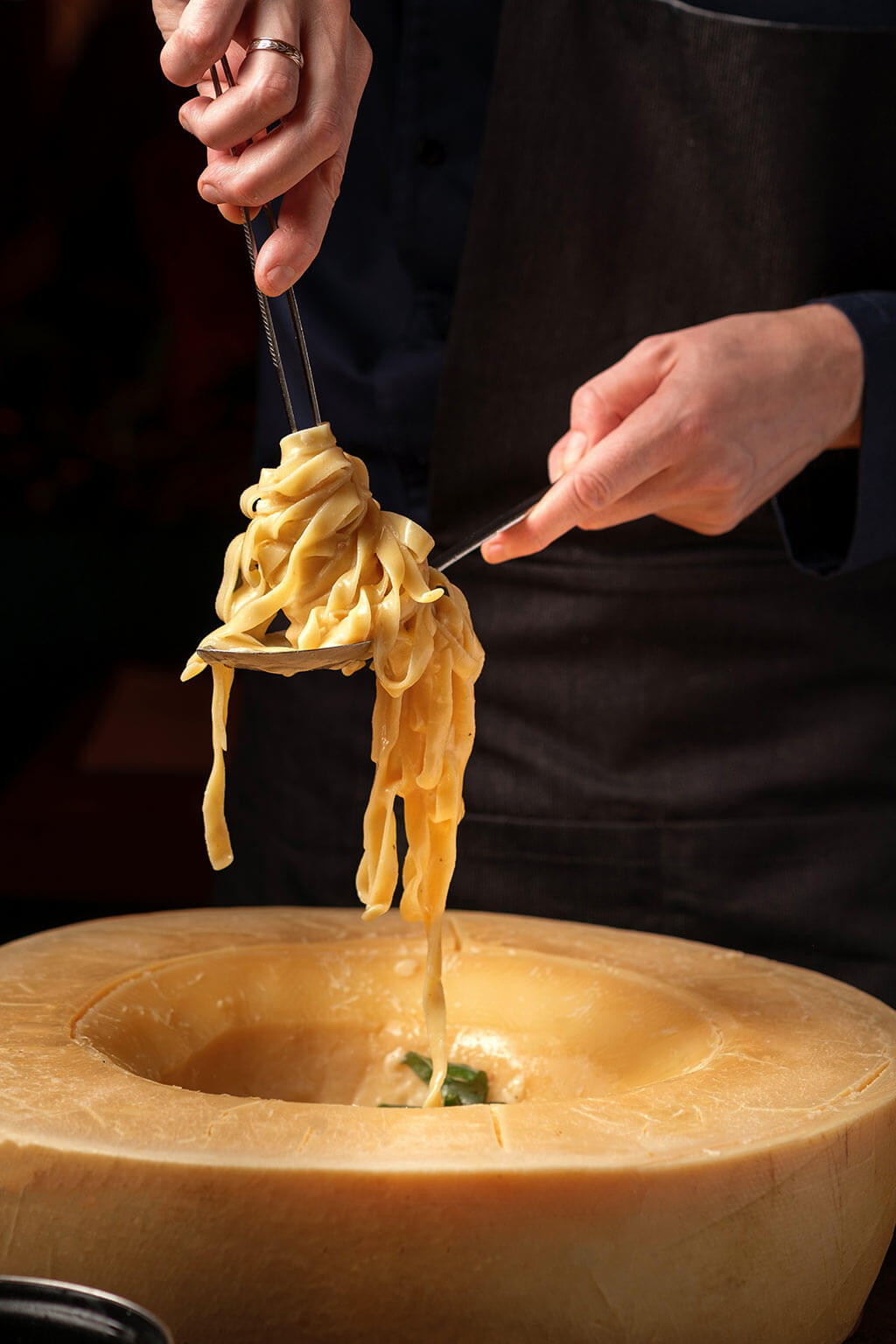Das Bild zeigt im Käselaib geschwenkte Pasta. Genießen Sie handgemachte italienische Nudeln im Al Porto Rostock, Ihrem Pasta Restaurant am Stadthafen.